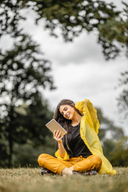 istock Beautiful woman reading e-book on digital tablet outdoors 1280215869