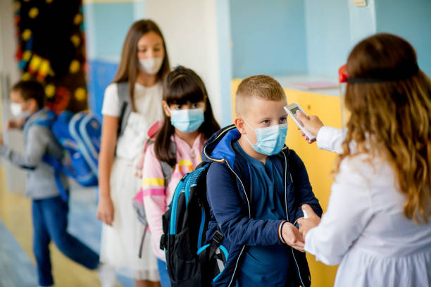 istock Teacher doing temperature check on school children 1280218024
