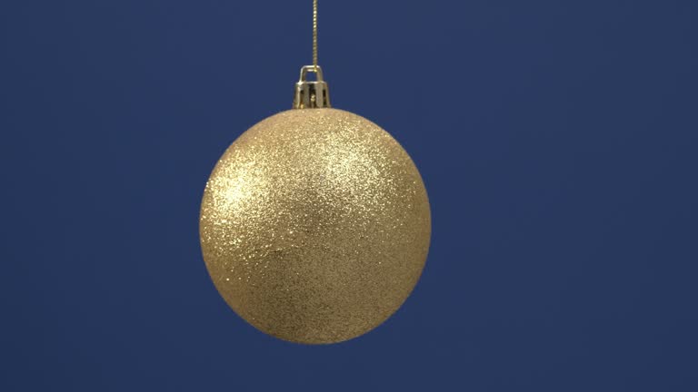 Christmas glittering decoration for the New Year tree hanging on a blue background.