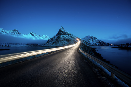 Olstind Mount and car light. Lofoten islands, spring time, Norway