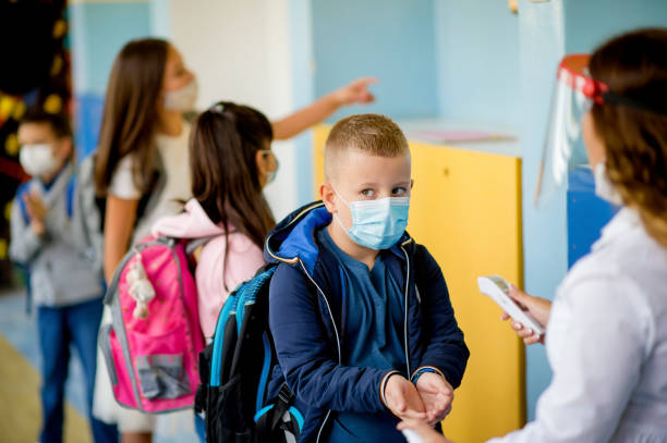istock Teacher doing temperature check on school children 1280218295