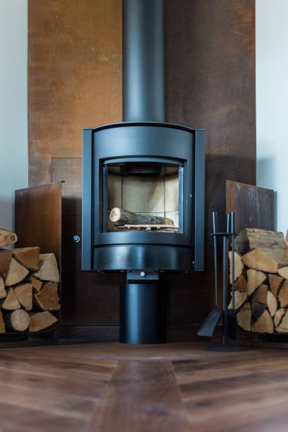 mag z kwadratu żeliwnego woodburner / współczesny piec opalany drewnem płaszcz kominkowy z pomarańczowymi płomieniami ognia płonącymi i wytwarzającymi ciepło do ogrzania pomieszczenia zamiast centralnego ogrzewania kotła gazowego, nowoczesny pie - log fire firewood fire chimney zdjęcia i obrazy z banku zdjęć