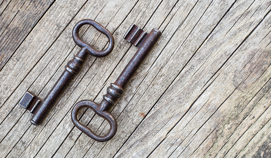 Old vintage iron keys on a wooden background, web banner with copy space, escape room game concept