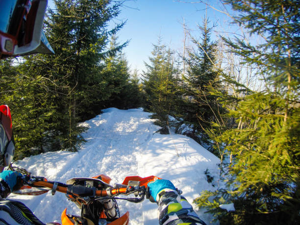 un homme monte un snowbike dans les montagnes. vue de la caméra sur le casque. clips de moto. forêt en hiver - snow jumping snowmobiling sled photos et images de collection