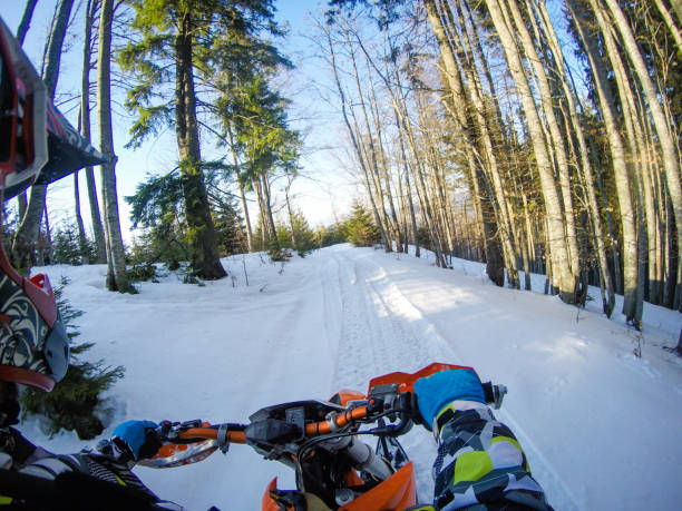 un homme monte un snowbike dans les montagnes. vue de la caméra sur le casque. clips de moto. forêt en hiver - snow jumping snowmobiling sled photos et images de collection