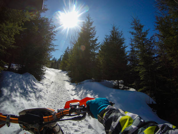 un homme monte un snowbike dans les montagnes. vue de la caméra sur le casque. clips de moto. forêt en hiver - snow jumping snowmobiling sled photos et images de collection