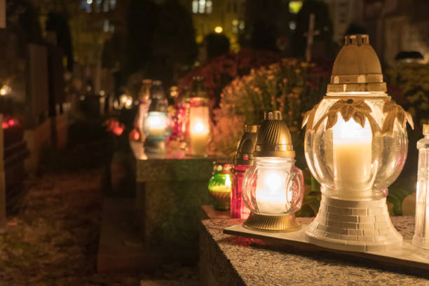 istock Close up on grave lanterns glowing on cemetery at night 1280223156
