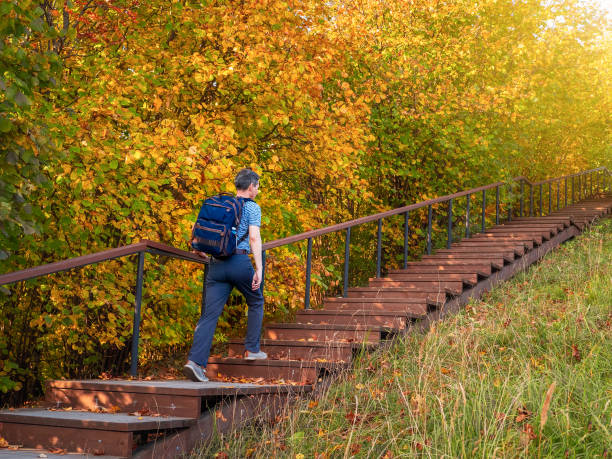 istock A man with a backpack climbs the eco trail, bottom-up view. 1280224331
