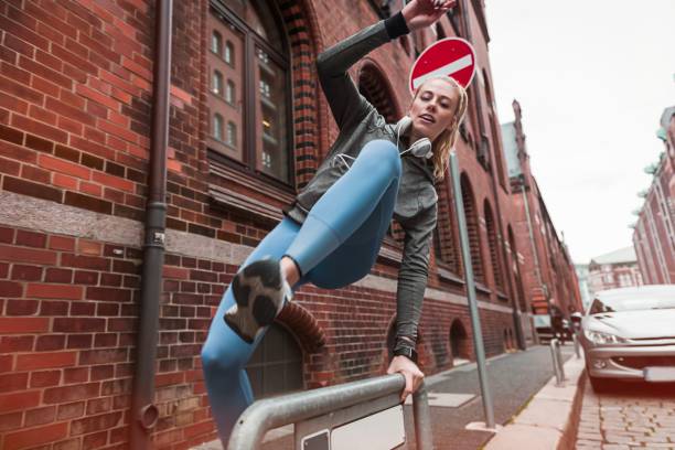 Close up of young attractive young woman , jumps over the fence