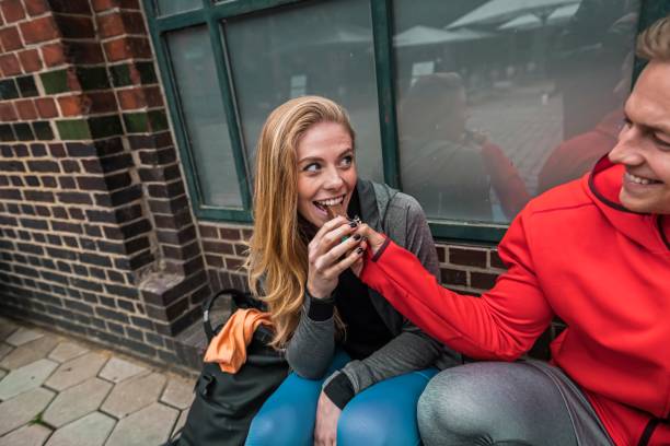 Cheerful sporty couple having pause on the sidewalk