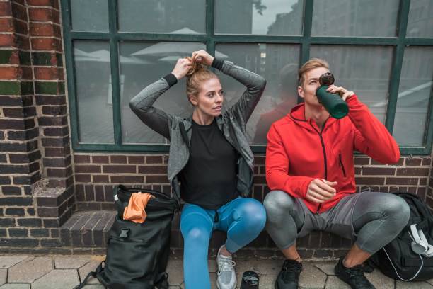 istock Cheerful sporty couple having pause on the sidewalk 1280226381