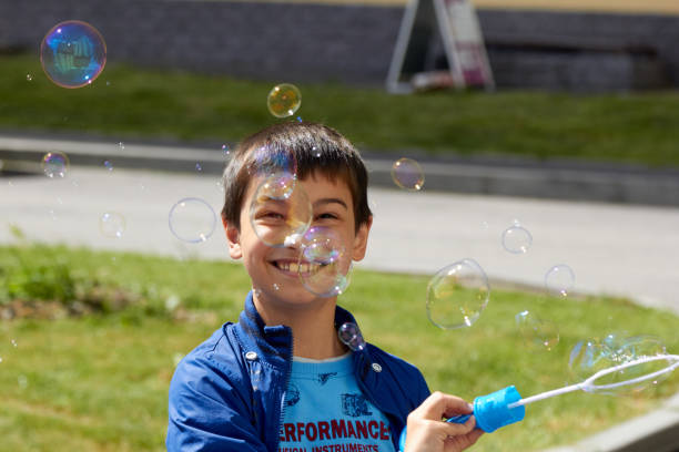 istock boy blowing bubbles in the summer sun joy 1280231279