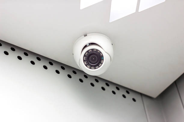 istock Modern white CCTV security camera on the ceiling in the office building 1280232996