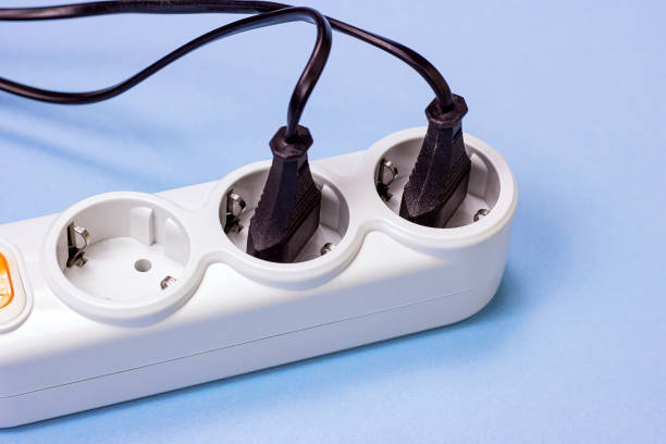 istock Triple socket white European power adapter with different wires at home. Standard electrical plug power outlet on blue background. 1280232997
