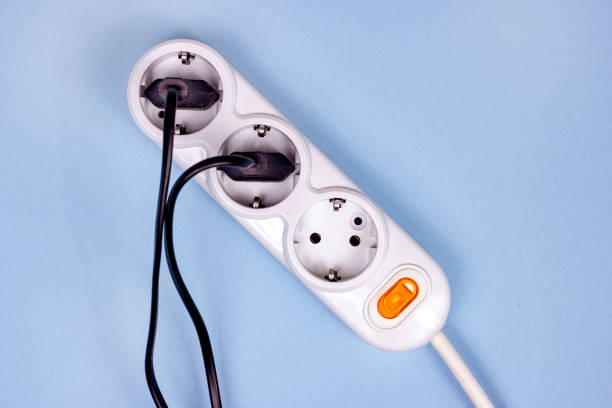 istock Top view of triple socket European power adapter with different wires at home. Standard electrical plug power outlet on blue background. 1280233003