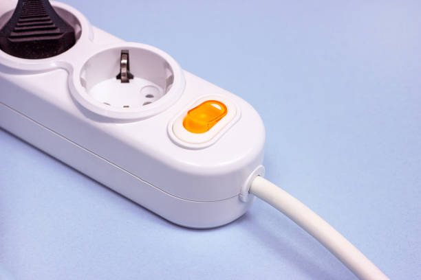 istock Triple socket white European power adapter with different wires at home. Standard electrical plug power outlet on blue background. 1280233005