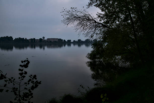 Lake at sunset in autumn framed by a tree with its reflection casted in the water