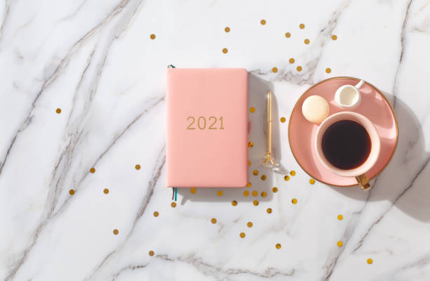 istock Notebook with empty pages for text, with pen, coffee cup, gift boxes, gold sparkles on white desk 1280234842
