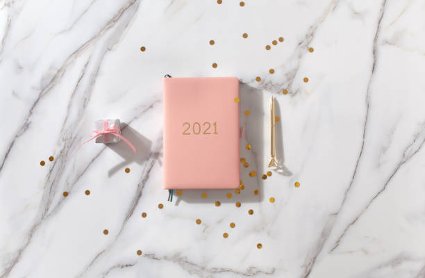 istock Notebook with empty pages for text, with pen, coffee cup, gift boxes, gold sparkles on white desk 1280234889