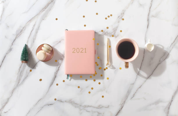 istock Flat lay composition with New Year's decoration, coral colored 2021 diary book and coffee cup and Macaron cookie 1280234994