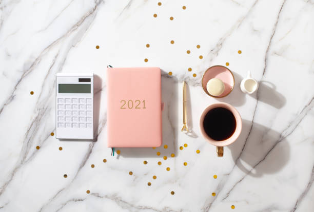 istock Notebook with empty pages for text, with pen, coffee cup, gift boxes, gold sparkles on white desk 1280235580