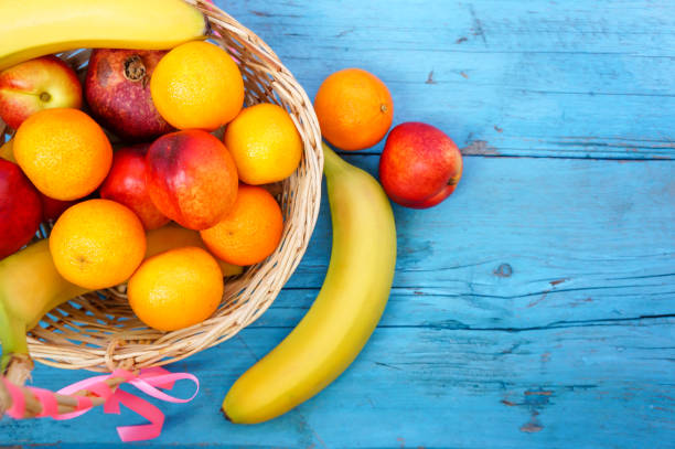 istock wicker basket with different fruits on a blue wooden background 1280236642