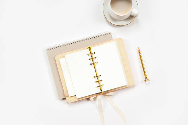 istock Notepad and beige leather covered diary with clean sheets, gold pen, cup of flat white coffee 1280236755