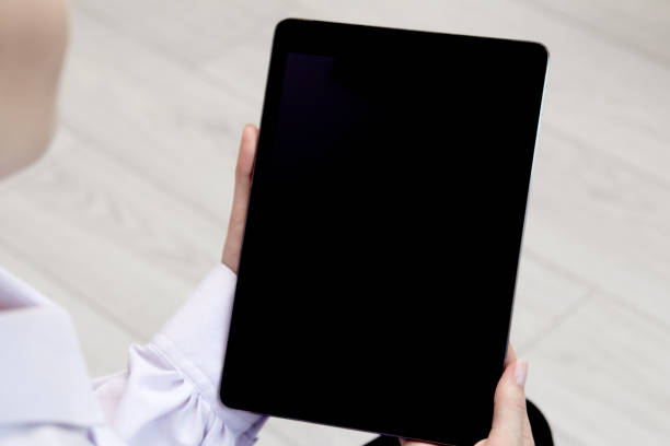 istock In women's hands, an electronic tablet with a black screen. 1280237538