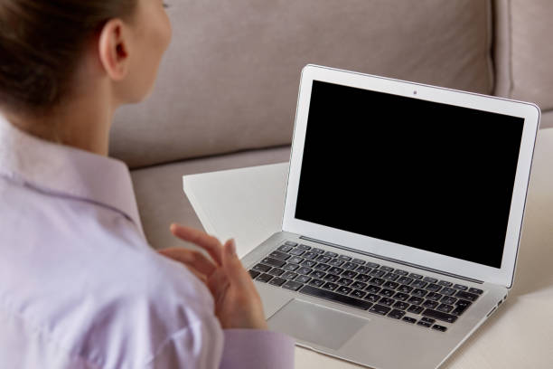 istock Laptop with a black blank screen, the girl is sitting back. 1280238254