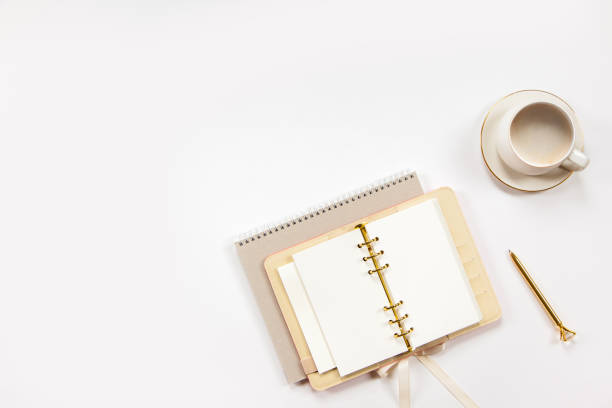 istock Notepad and beige leather covered diary with clean sheets, gold pen, cup of flat white coffee 1280238263