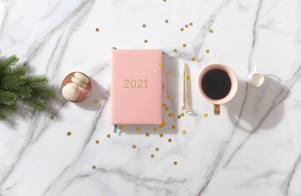 istock Flat lay composition with New Year's decoration, coral colored 2021 diary book and coffee cup and Macaron cookie 1280238441