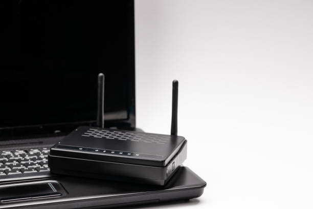 istock black wifi router and laptop over white background. online and network conceptual. copy space. studio shot 1280239283