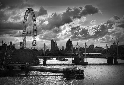 Monochrome pic of Festival Pier on the river Thames with London skyline looking towards Westminster and Hungerford Bridge