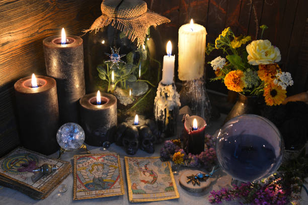 Mysterious still life with old tarot cards, crystal ball and black candles on witch table stock photo
