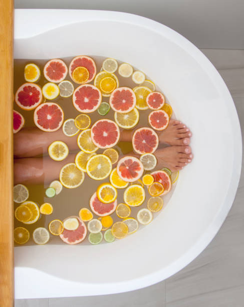 istock Top view orange, lemon, grapefruit slices and woman legs in bathtub 1280249620