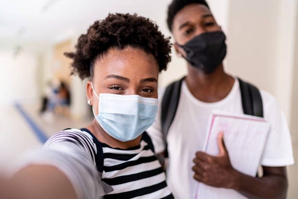 Friends wearing face mask taking a selfie at school Friends wearing face mask taking a selfie at school teenagers only teenager multi ethnic group student stock pictures, royalty-free photos & images