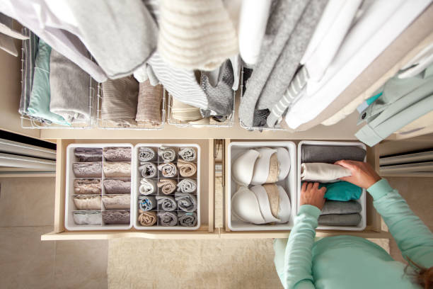 Unidentified neat housewife puts container with socks, panties and underwear. Clothes storage Unidentified neat housewife puts container with socks and pantyhose on wardrobe drawer during general cleaning by modern storage system. Concept of beautiful and comfortable organization tidy stock pictures, royalty-free photos & images