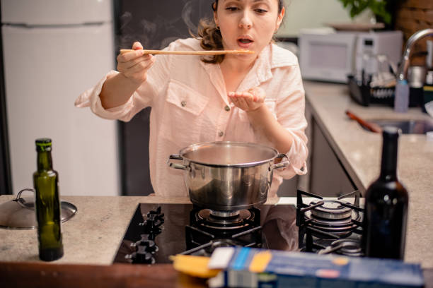 istock Woman tasting food from the pan with bamboo spoon 1280256176