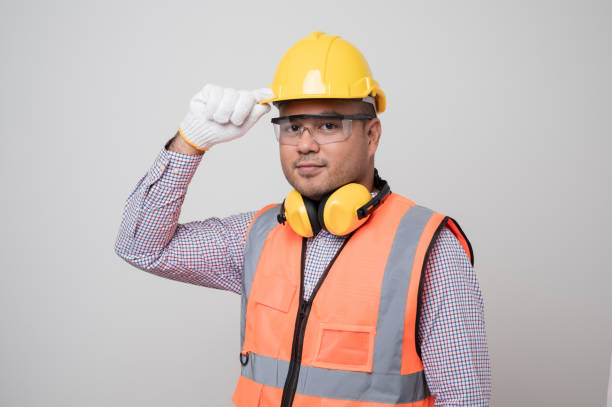 istock Young asian civil engineer in uniform earmuff helmet safety glasses standing in studio isolated white background. Mechanic home service concept. 1280258901