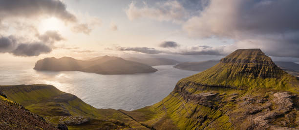Faroe Islands Roam Sunset Panorama Skælingsfjall Mountain View to Vágar Island Faroe Islands Vágar Island - Vagar Island Sunset XXXL Panorama View from Sornfelli close the Skælingsfjall Mountain Range on Streymoy Island in warm moody sunset light. Vagar Island under atmospheric moody sunset light on the north atlantic ocean horizon. Skælingsfjall Mountain Range on Streymoy Island in the foreground, 74 MegaPixel Stiched Panorama Sornfelli, Skælingur, Streymoy Island, Faroe Islands, Kingdom of Denmark, Nordic Countries, Europe vágar photos stock pictures, royalty-free photos & images