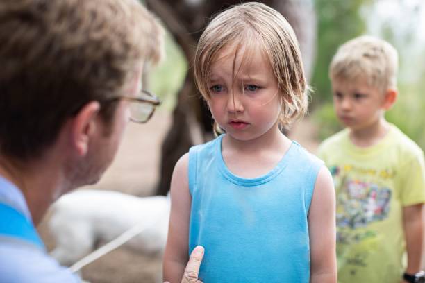 Parent disciplining and talking to his kid. Young boy looks sad and down while his father corrects him for something he did wrong Punishment stock pictures, royalty-free photos & images