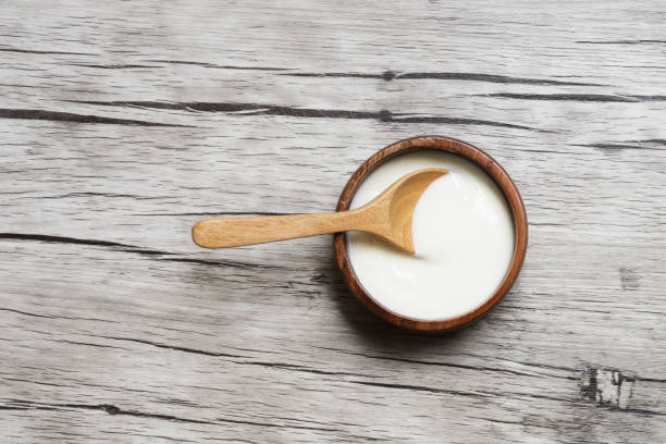 istock Yogurt in a wooden cup with copy space on wood  background 1280271307
