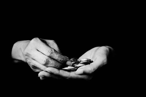 Money coin in hand black and white photo on black background - Black and white photo of coins in old wrinkled hands close-up Thailand, Abandoned, Alms, Assistance, Beggar, Money coin, Finger, Hand, Black and white photo alms stock pictures, royalty-free photos & images