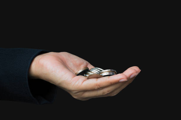 istock Coins in hand on black background human body part 1280271350