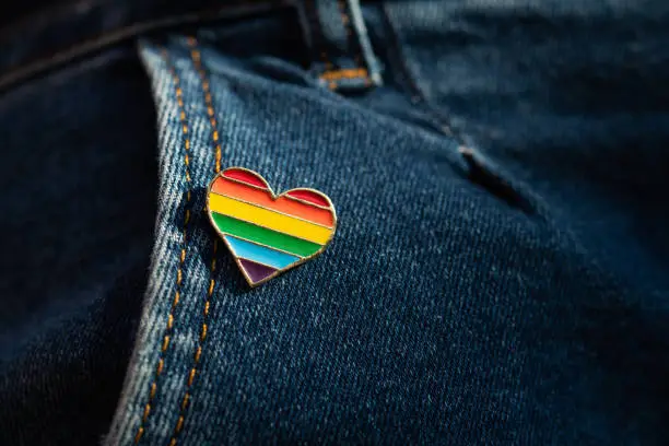 Rainbow color lgbt heart badge on jeans. Closeup photo. Freedom concept parade.