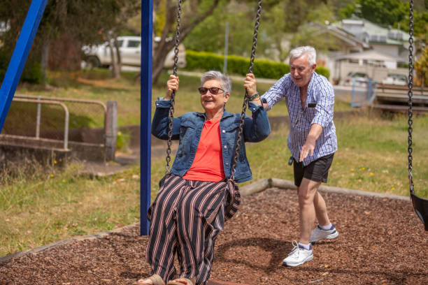 istock Active Senior Couple Playing on a Swing in the Park 1280273075