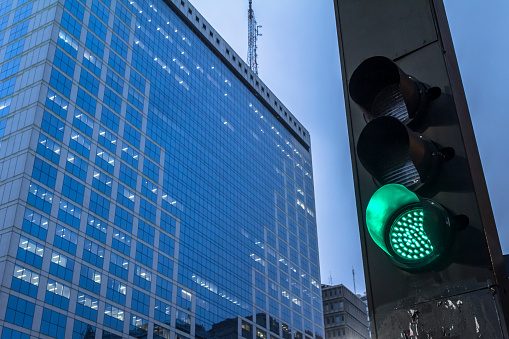 green semaphore on Paulista Avenue with office buildings background in Sao Paulo city