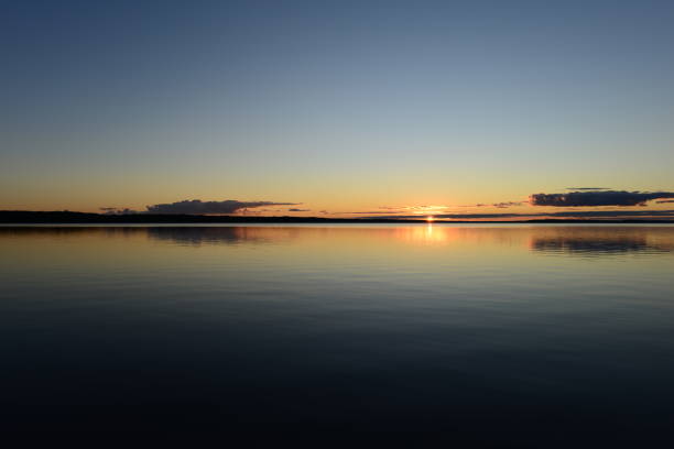 istock Sunset on the horizon over a calm water surface lake 1280277107