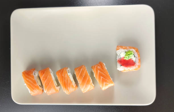 istock Plate of salmon sushi on black background 1280281700