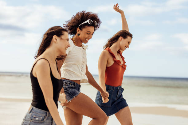 istock Happy friends walking on beach 1280283631